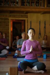 Women in yoga pose meditating at Feathered Pipe Ranch in Montana.