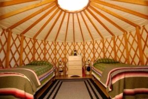 Twin beds in a circle tent at Feathered Pipe Ranch in Montana.
