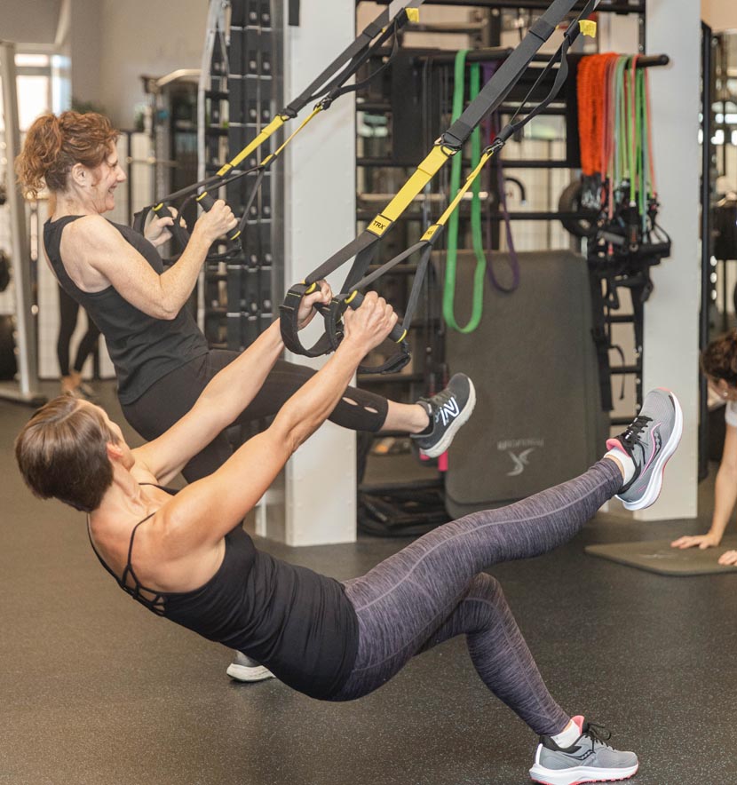 Students using weight resistance machines to strengthen upper body muscles.