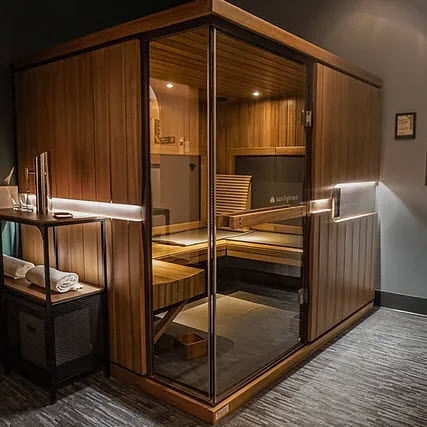 Outside view of infrared sauna made of wood with a glass door.