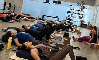 Well Studio members on mats during Sacred Sunday, a yoga class offered on Sundays with Stacy.