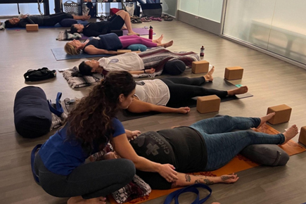 Instructor adjusting position of student during a restorative meditation session at Well Studio Dublin.